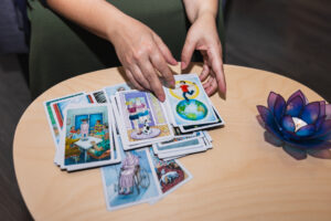 Persona seleccionando cartas terapéuticas dispuestas sobre una mesa como herramienta de expresión emocional